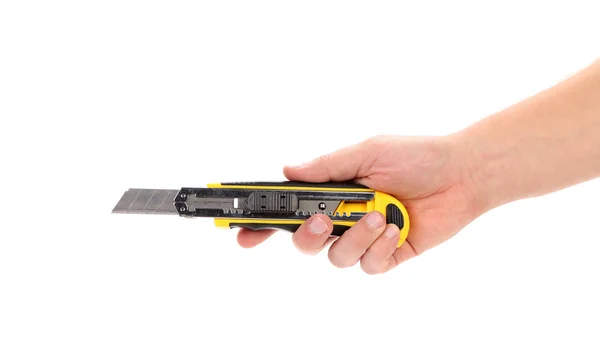 Ręka trzyma nóż żółty papeterii — Zdjęcie stockowe