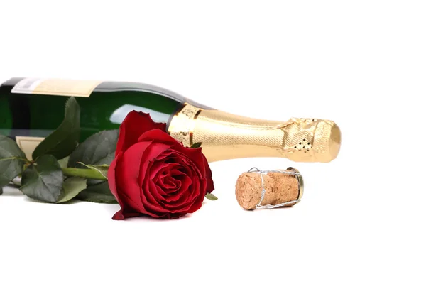 Κόκκινο τριαντάφυλλο και ένα μπουκάλι σαμπάνια. — Φωτογραφία Αρχείου
