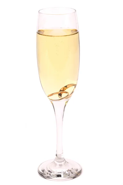 Glass of champagne with wedding rings — Stock Photo, Image