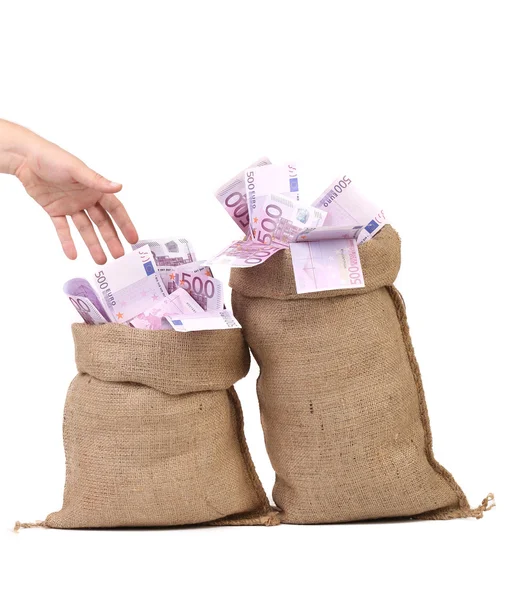 Hand to sacks with euro bills. — Stock Photo, Image