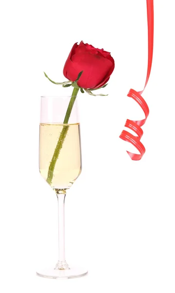 Rote Rose im Glas Champagner und Papierschlange. — Stockfoto