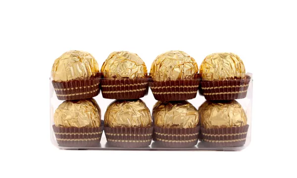 Twee rijen van goud chocolade bonbons. — Stockfoto