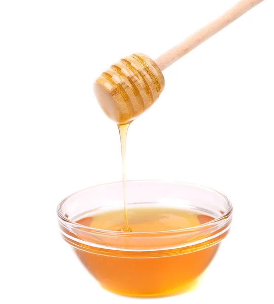 Honey dripping from a wooden dipper. — Stock Photo, Image