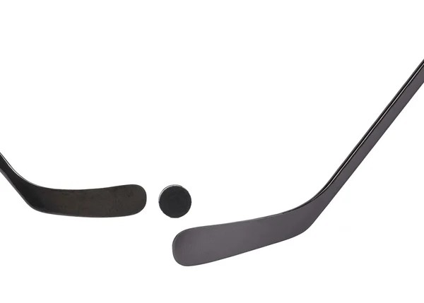 Twee black ice hockeystick en puck. — Stockfoto
