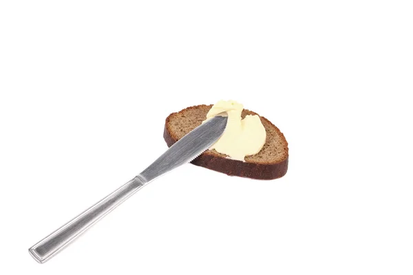 Buttering knife on brown bread — Stock Photo, Image