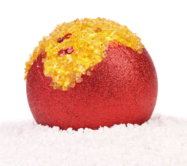 Christmas red ball with orange stones on snow — Stock Photo, Image