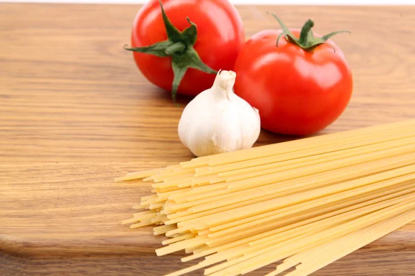 Spaghetti and tomatoes on board. — Stock Photo, Image