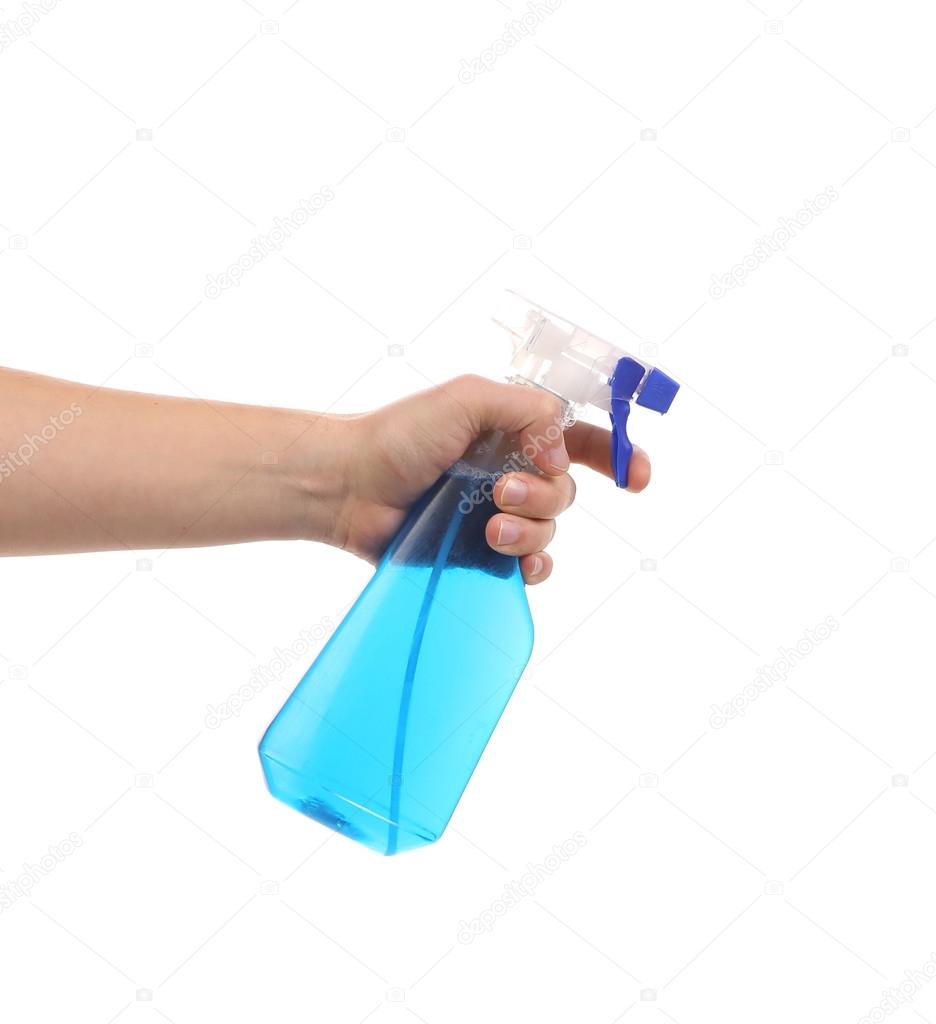 Hand holding blue plastic spray bottle.