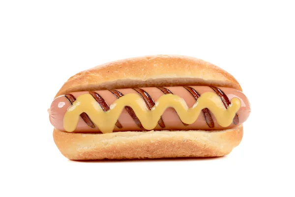 Hand houden hotdog met mosterd. — Stockfoto