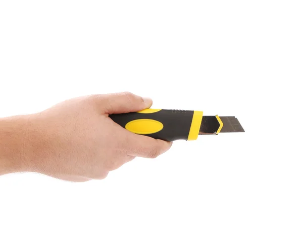 Ręka trzyma nóż żółty papeterii. — Zdjęcie stockowe