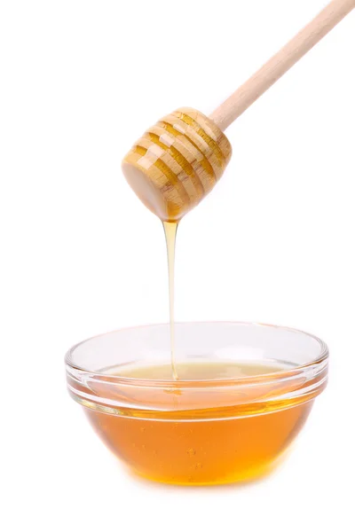 Honey dripping from a wooden dipper. — Stock Photo, Image