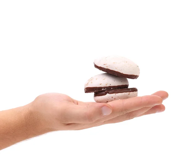 Galletas de beso blanco con chocolate en la mano . —  Fotos de Stock