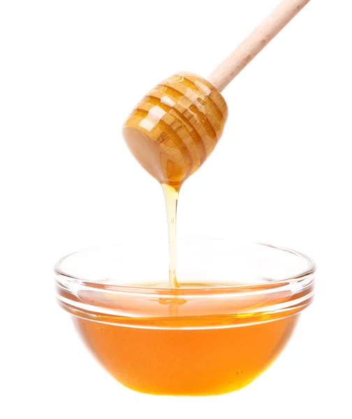 Bow of honey and wooden spoon — Stock Photo, Image