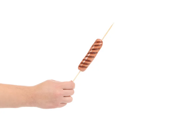 Hand holds sausage roll grilled — Stock Photo, Image