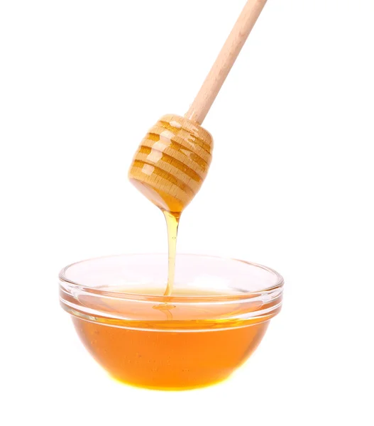 Honey flowing on spoon in a bowl. — Stock Photo, Image