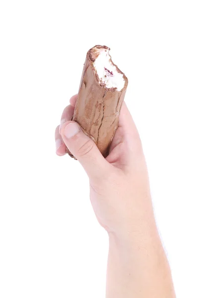 Hand holds a roll of chocolate ice cream — 图库照片