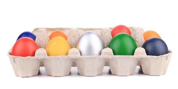 Cardboard egg box with Easter colored eggs. — Stock Photo, Image