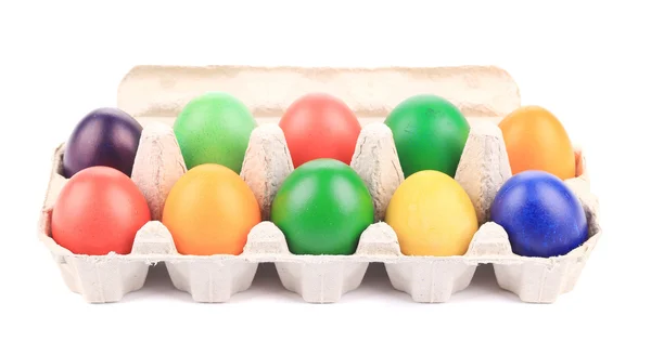 Cardboard egg box with Easter colored eggs — Stock Photo, Image