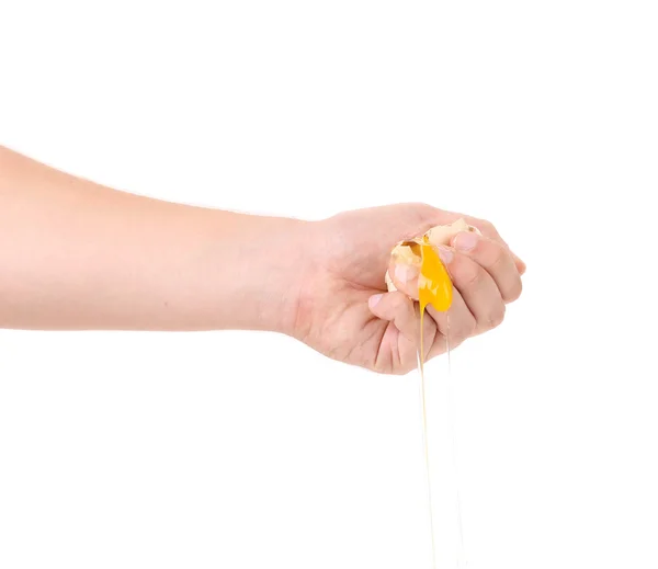 Рука разбивает яичный желток — стоковое фото