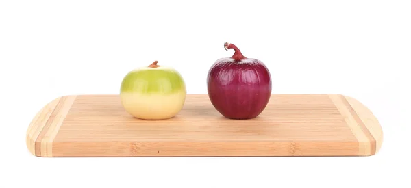 Красный и белый лук на деревянной тарелке — стоковое фото