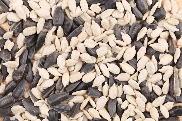 Sunflower seeds in shell and peeled. — Stock Photo, Image