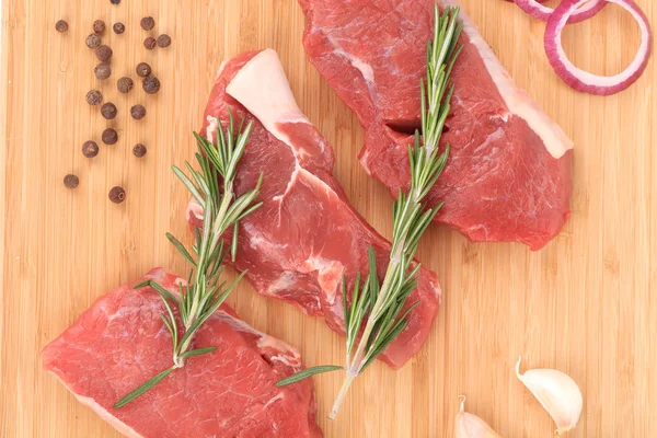 Bifes de carne de vaca crua em um conselho . — Fotografia de Stock