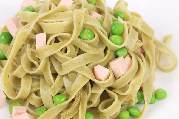 Pasta tagliatelle met groene erwten en ham. — Stockfoto