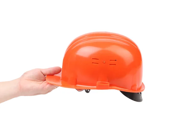 Ręka trzyma pomarańczowy kapelusz twardy. — Zdjęcie stockowe