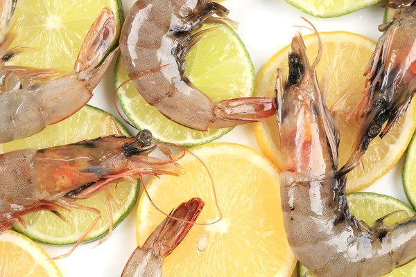 Raw shrimps on plate with lemon and lime. — Stock Photo, Image