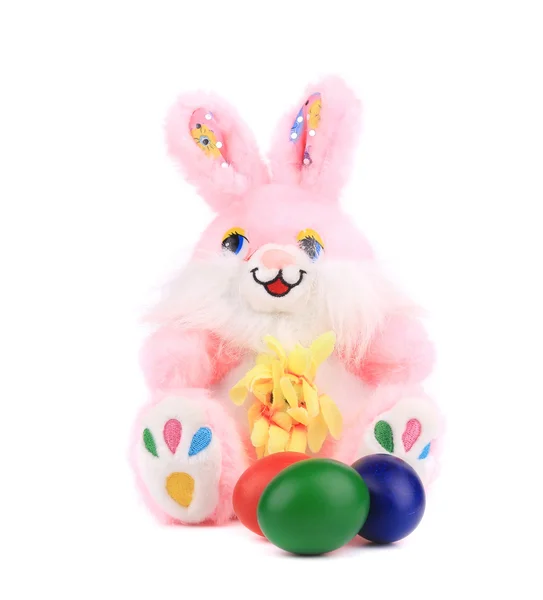 Coelho de brinquedo rosa com ovos de Páscoa . — Fotografia de Stock