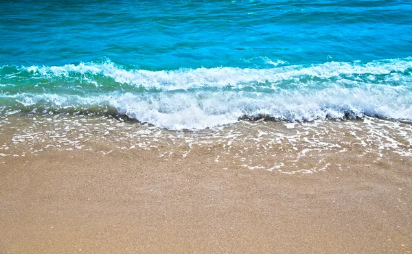 Blue wave gently stroking the sandy shore. — Stock Photo, Image