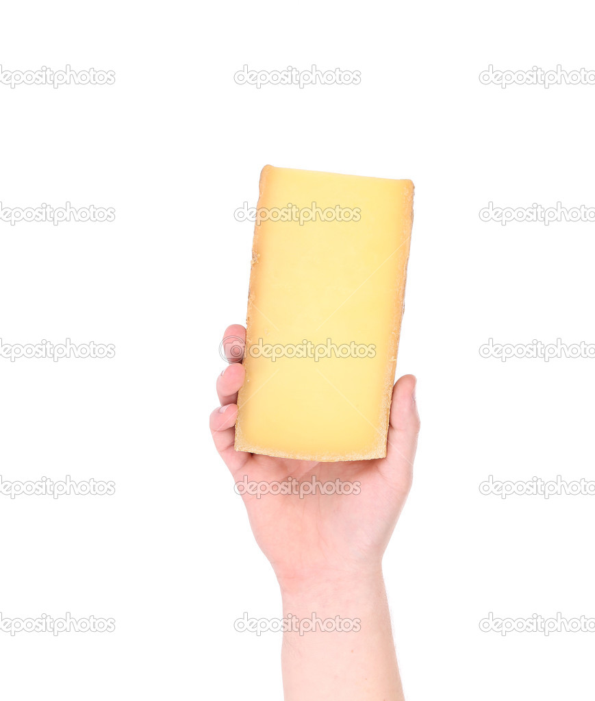 Hand holding block of parmesan cheese.