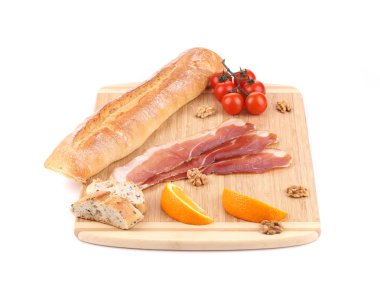 Prosciutto ve kesme tahtası üzerinde domates.