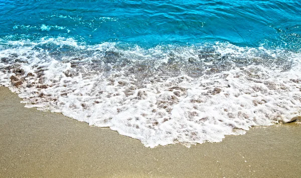Zonnige zand en golf op de zee. — Stockfoto