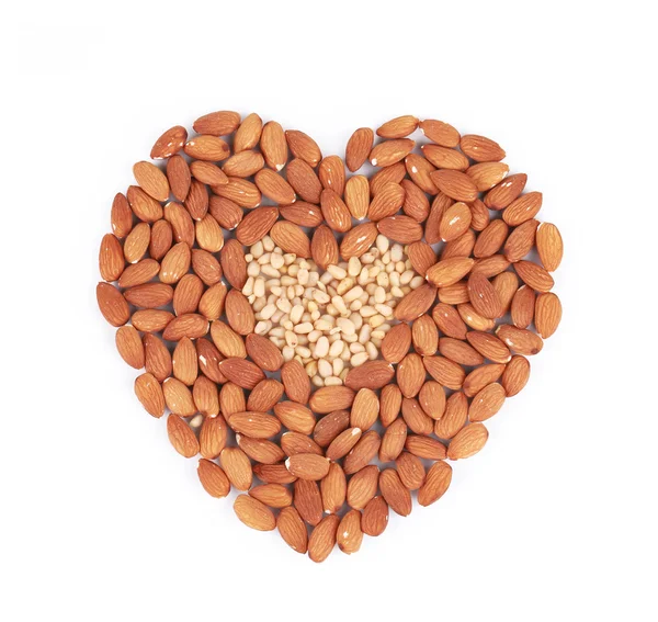 Heart shape of almonds and pine nuts. — Stock Photo, Image