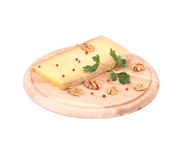 Сыр на деревянной тарелке с грецкими орехами . — стоковое фото