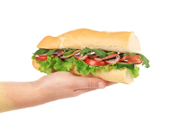 Hand holds french baguette sandwich. — Stock Photo, Image