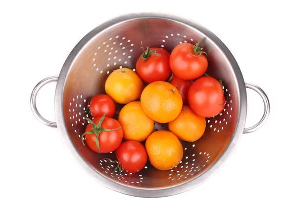 Tomatoes and mandarins in colander. — Stock Photo, Image