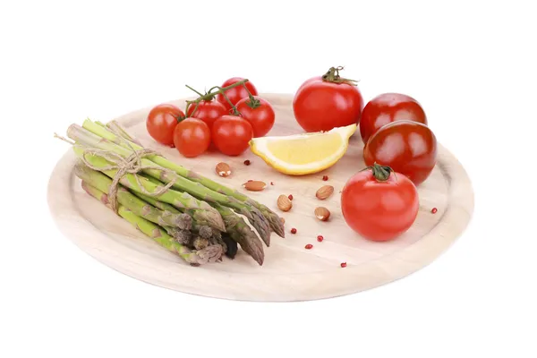 Espárragos y tomates sobre tabla de madera . —  Fotos de Stock