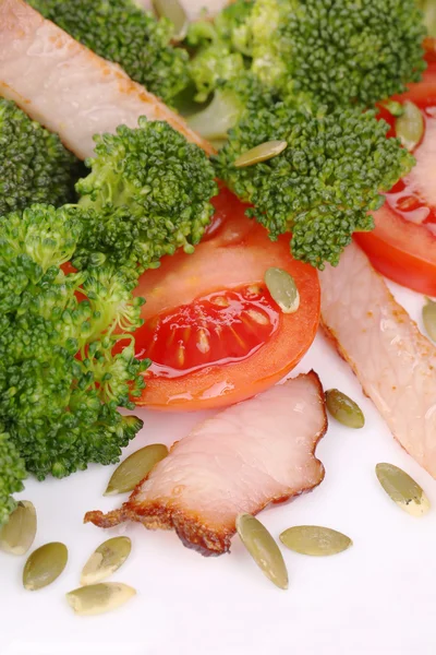 Broccoli salad with pumpkin seeds and tomatoes.