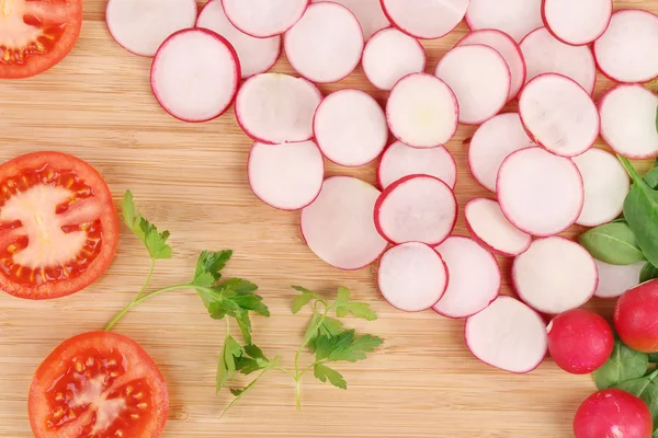 Ředkvičky okurka a rajčata na podnose. — Stock fotografie