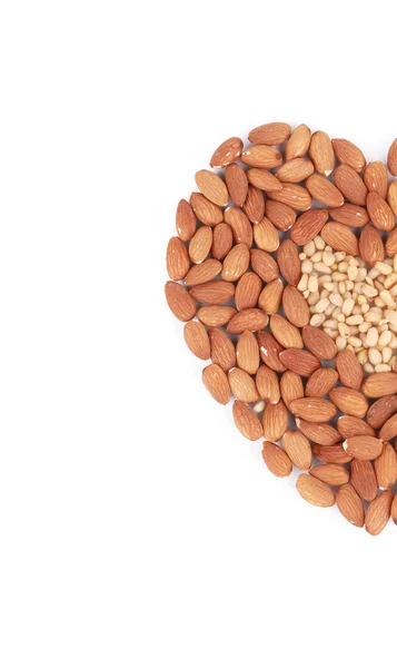 Heart shape of almonds and pine nuts. — Stock Photo, Image