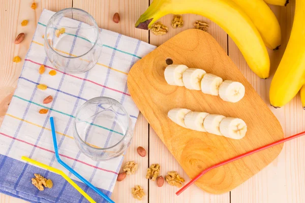 Nüsse und Bananen auf Holz. — Stockfoto