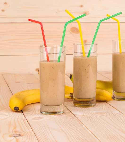 Närbild på banan smoothie och frukt på trä. — Stockfoto
