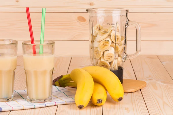 Banana juice and blender full of sliced fruits. — Stock Photo, Image