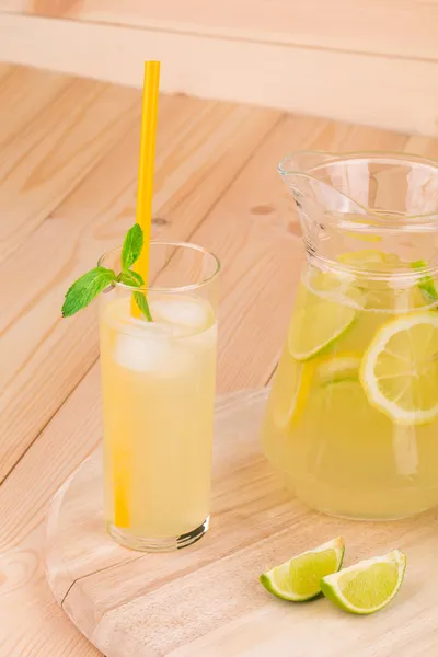 Brocca piena di limonata sul tavolo di legno . — Foto Stock
