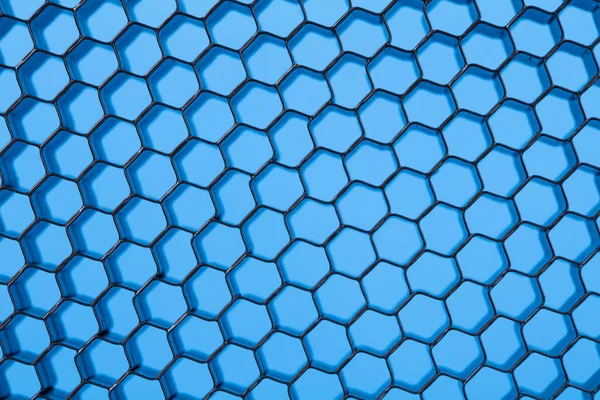 Honeycomb grid against blue background — Stock Photo, Image