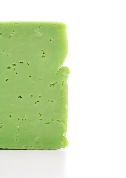 Brânză verde cu găuri pe un fundal alb — Fotografie, imagine de stoc