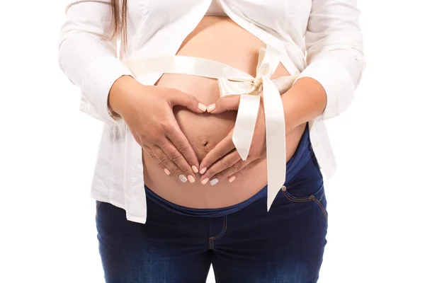 Mujer embarazada sosteniendo sus manos en forma de corazón — Foto de Stock