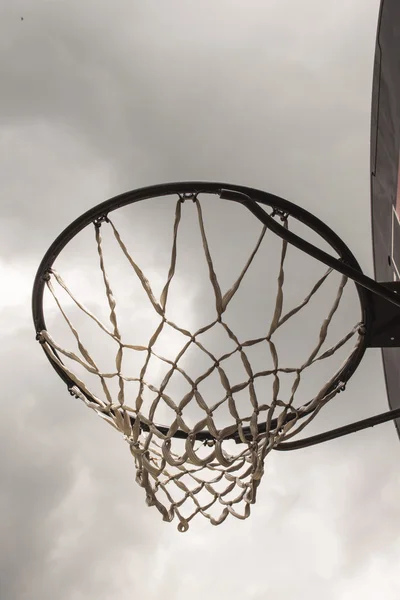 Mira el cielo a través de un aro de baloncesto . — Foto de Stock